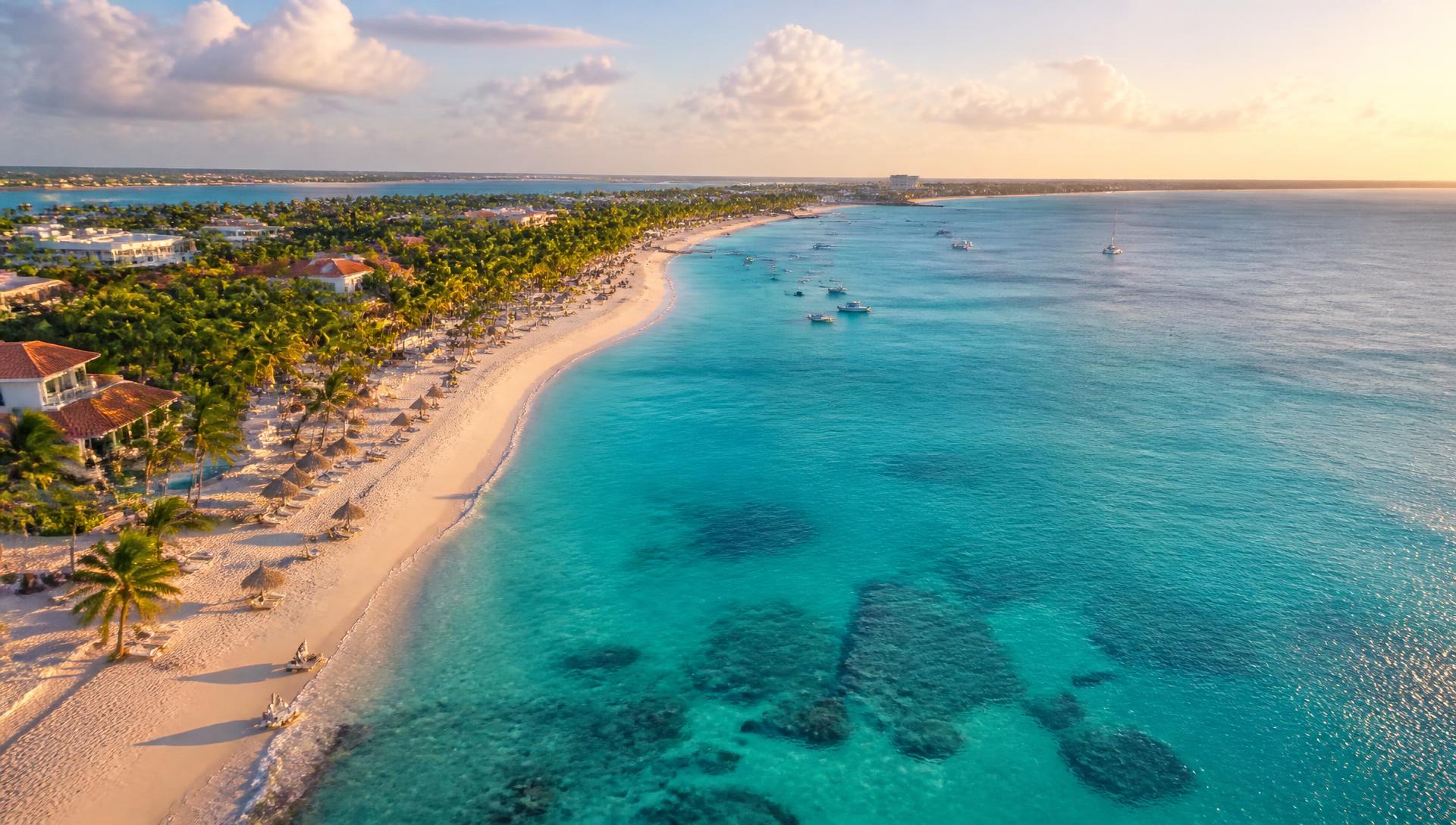 Playa caribeña con aguas turquesas y palmeras al atardecer